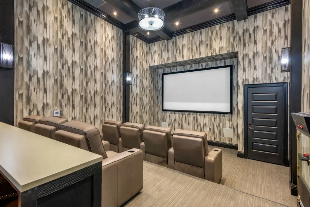 Modern on-site movie theater at The Ellery featuring tiered plush seating, a large cinema screen, and a cozy atmosphere for residents.