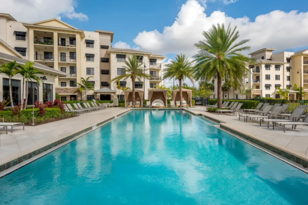 Resort-style swimming pool at The Ellery apartments in Plantation, FL, featuring luxury poolside cabanas and modern apartment